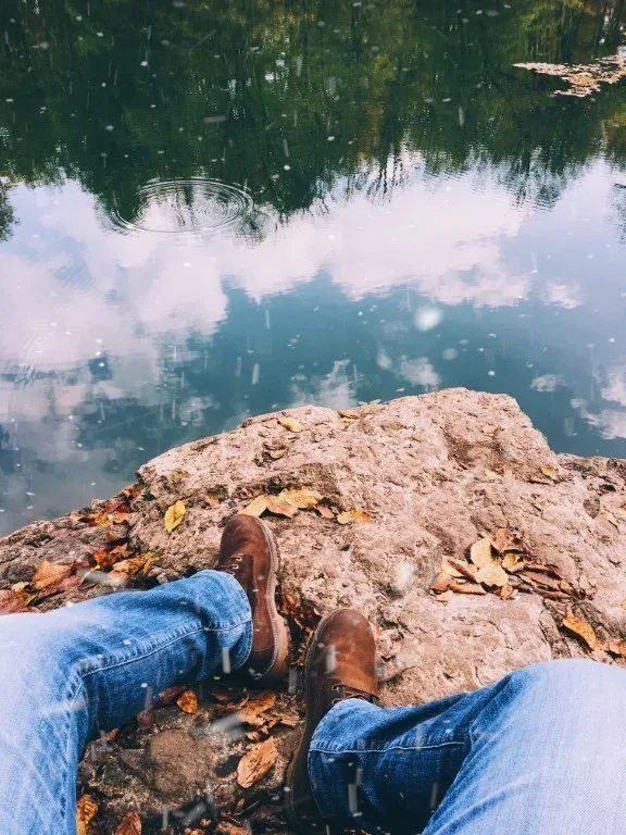 A person's legs resting on a sunlit rock