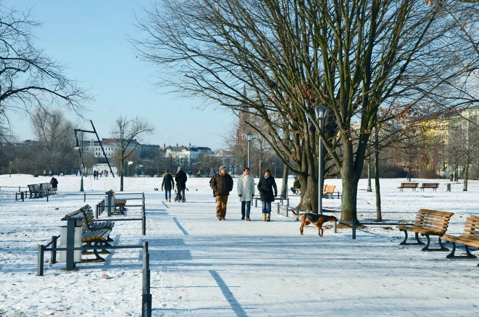 People walking through a snow-covered Berlin park