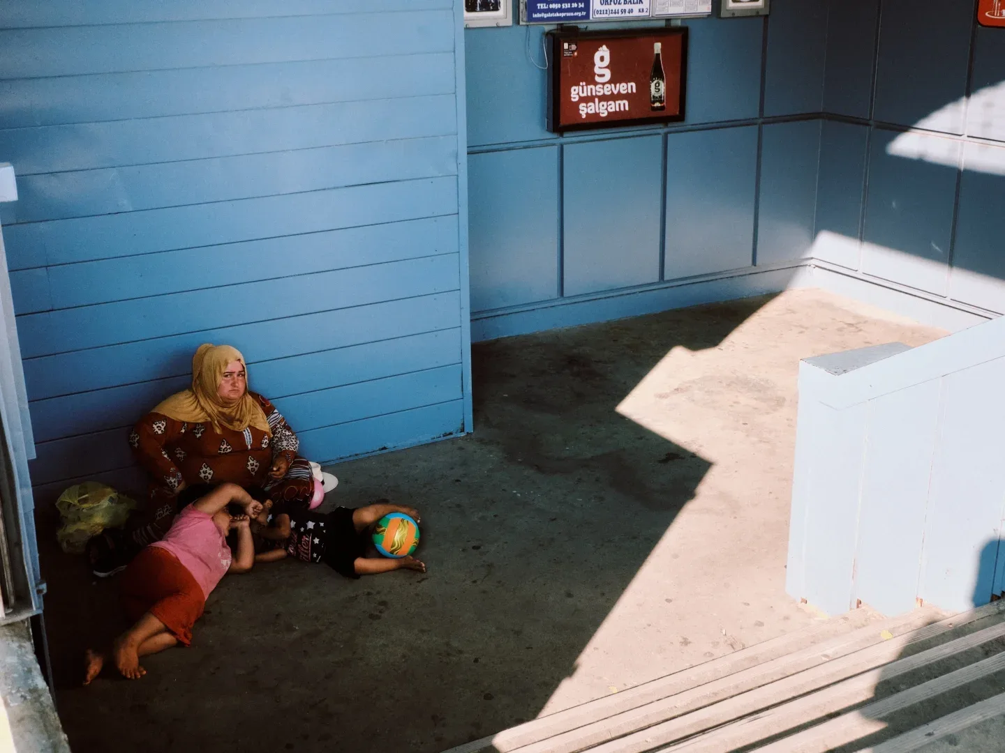A woman resting beside a blue wall
